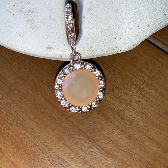 Peach colored earrings surrounded by crystals. - Picture 3 of 5